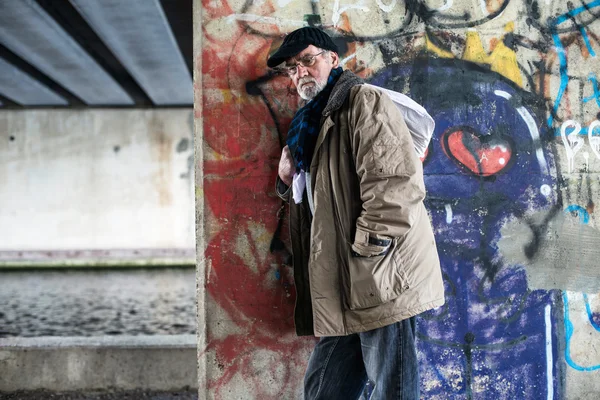 Obdachloser lehnt an Betonpfeiler — Stockfoto
