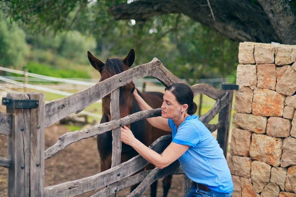 Brunette vrouw knuffelen paard — Stockfoto