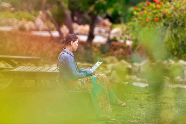 Frau sitzt am Tisch im Garten — Stockfoto