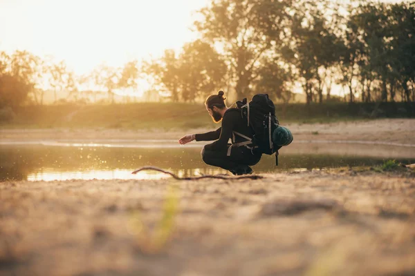 Backpacker in lake spelen met water — Stockfoto
