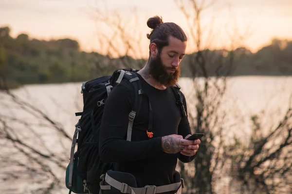 Skäggiga hiker kontroll mobiltelefon — Stockfoto