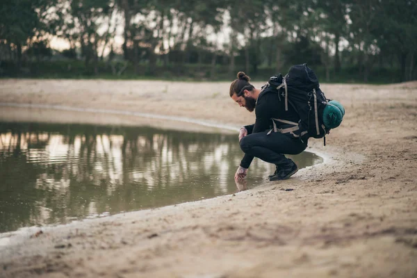 Backpacker gevoel water van lake — Stockfoto