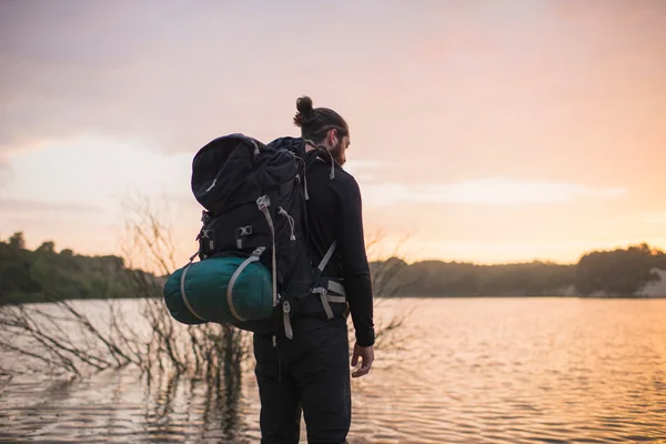 Bakifrån av hiker tittar över sjön — Stockfoto