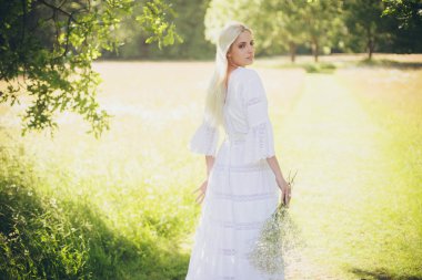 Ağaç gölgesinde duran sarı gelin