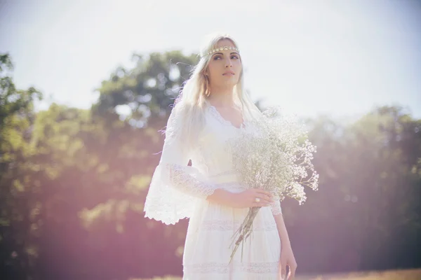 Blonde bride holding white flowers