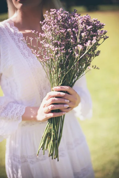 Noiva segurando buquê roxo — Fotografia de Stock