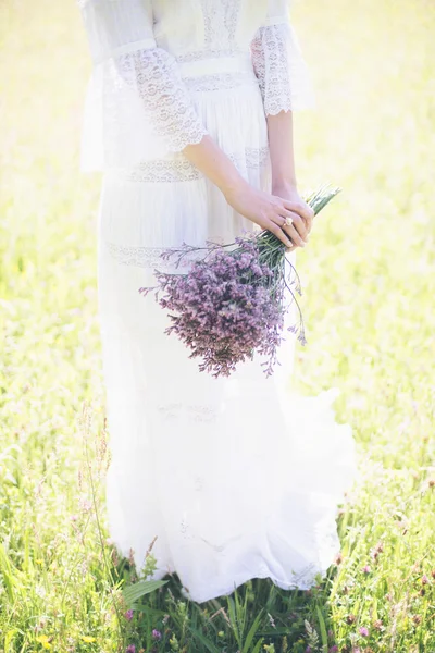 Mariée tenant bouquet de fleurs pourpres — Photo