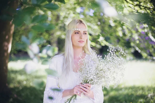 Noiva com flores brancas sob a árvore — Fotografia de Stock