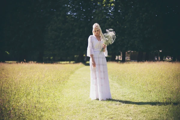 Panna Młoda z białych kwiatów, stojąc w dziedzinie — Zdjęcie stockowe