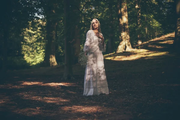 Sposa bionda in piedi nella foresta — Foto Stock