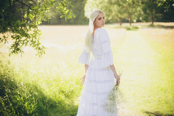 Blonde bride standing in tree shadow — Stock Photo, Image