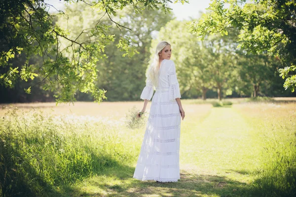 Blonde bride standing in tree shadow — Stock Photo, Image