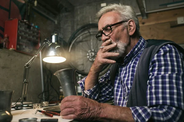 Man inspecting tin vase