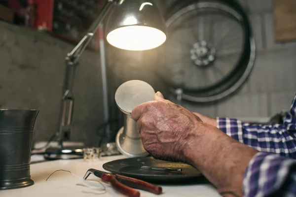 Man inspecting antique tin vase — Stock Photo, Image