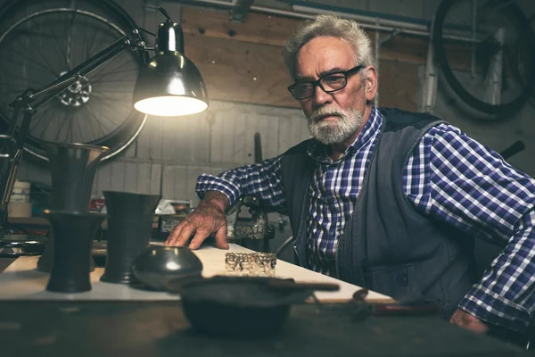 Thoughtful senior man in workshop — Stock Photo, Image