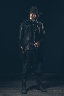 Kendine güvenen kovboy gösteren tabanca