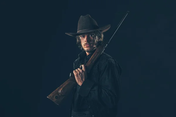 Retro cowboy standing with rifle — Stock Photo, Image