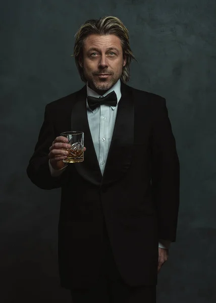 Zufriedener Blonder Mann Mit Stoppelbart Smoking Mit Einem Glas Whisky — Stockfoto