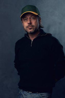 Koyu yeşil yün kazaklı sarışın bir adamın portresi..