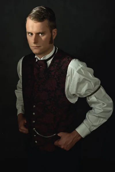 一个身穿维多利亚时代旧式服装的年轻人在黑暗的灰色墙壁前的影子画像 — 图库照片