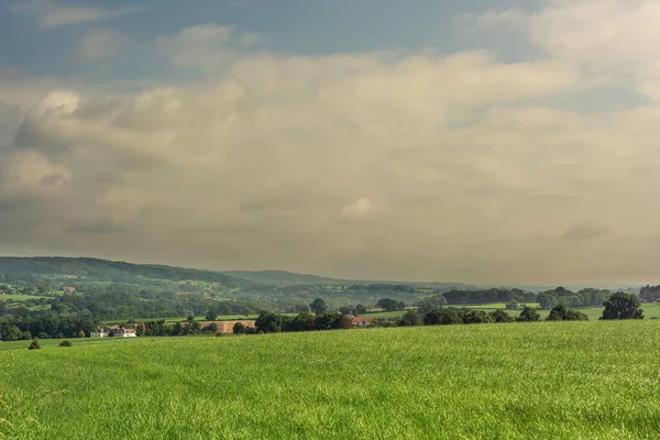 Lush Hilly Landscape Meadows Trees Houses Cloudy Sky — Stock Photo, Image