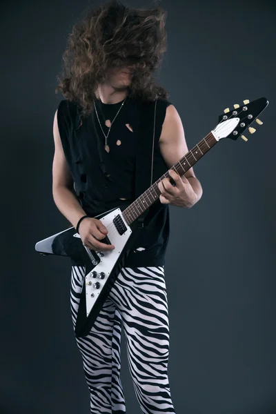 Αρσενικό σκληρό ροκ μουσικός ηλεκτρική κιθάρα με μακριά μαλλιά. στούντιο με — Φωτογραφία Αρχείου