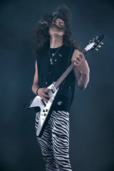 Αρσενικό σκληρό ροκ μουσικός ηλεκτρική κιθάρα με μακριά μαλλιά. στούντιο με — Φωτογραφία Αρχείου