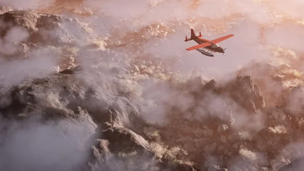 Aérien d'un avion rouge survolant un paysage de montagne rocheux gris — Photo