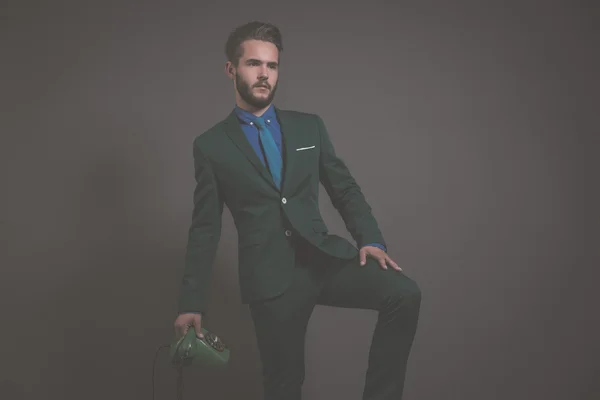 Business fashion man wearing green suit with blue shirt and tie.