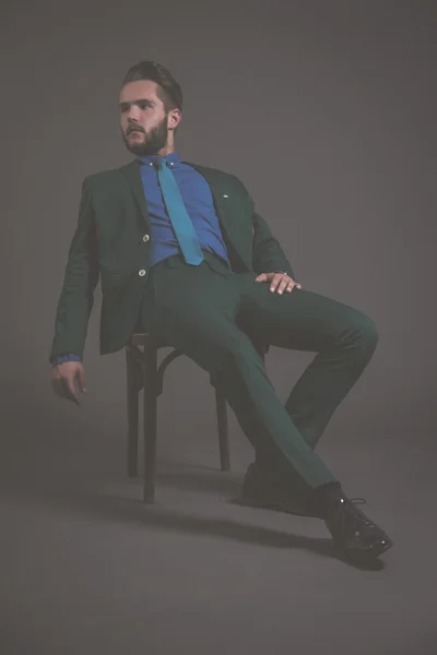 Άνθρωπος των επιχειρήσεων μόδας φοράει πράσινο κοστούμι με μπλε πουκάμισο και γραβάτα. — Φωτογραφία Αρχείου