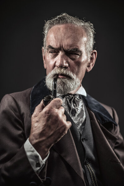 Pipe smoking vintage characteristic senior man with gray hair an