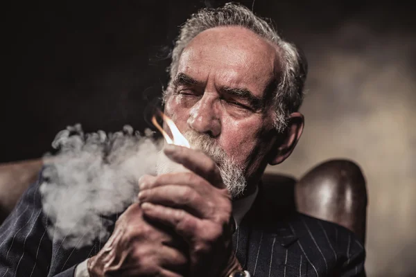 In chair sitting characteristic senior business man. Smoking cig — Stock Photo, Image