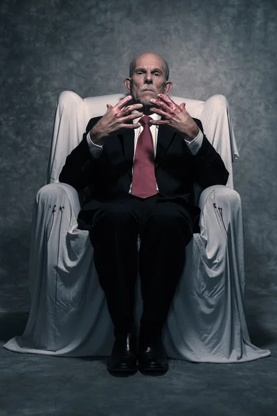 Bad businessman with bloody hands sitting in white chair. Gray b — Stock Photo, Image