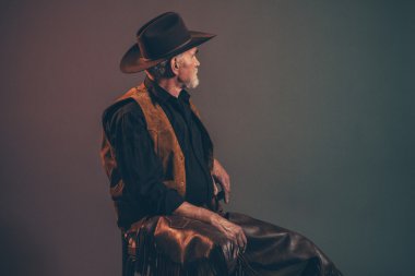 Gri sakallı ve kahverengi şapka ile eski kaba batı kovboy. Düşük anahtar 