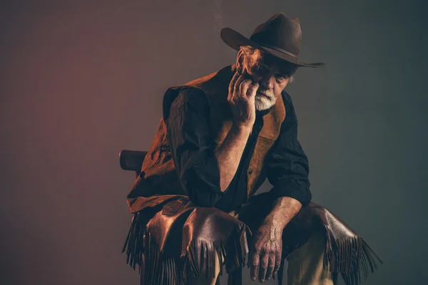 Fumo di sigaretta vecchio cowboy occidentale ruvido con barba grigia e b — Foto Stock