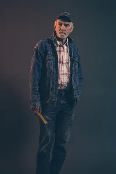 Senior carpenter with gray hair and beard holding yellow measuri — Stock Photo, Image