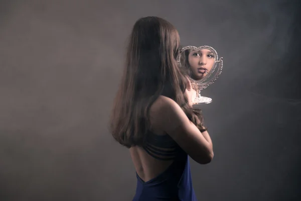 Девочка-подросток с длинными каштановыми волосами делает помаду и держит свет — стоковое фото