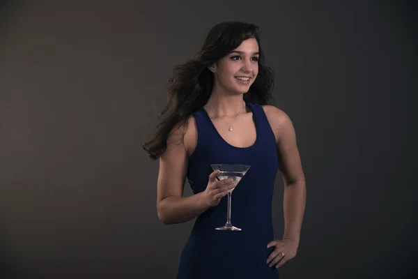 Bella ragazza bruna adolescente che tiene il bicchiere da cocktail con indosso blu — Foto Stock