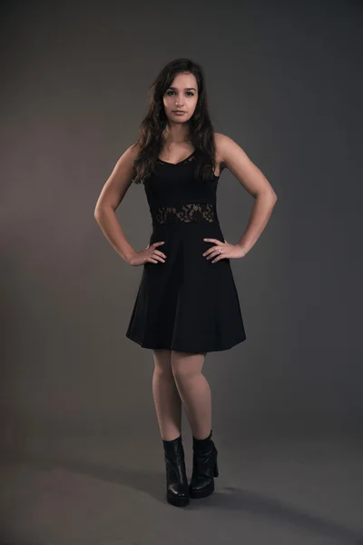 Carino ragazza bruna adolescente che indossa un vestito nero. Studio moda s — Foto Stock