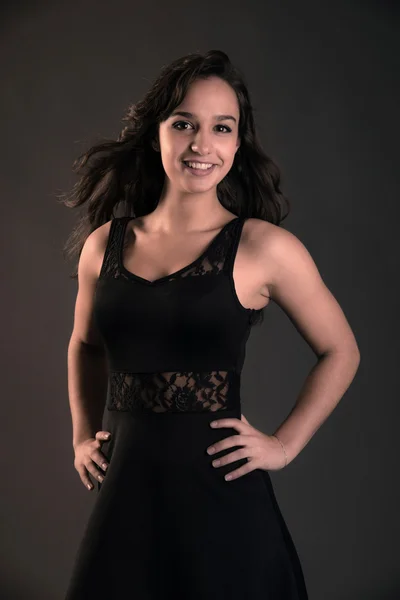 Smiling cute brunette teenage girl wearing black dress. Studio f — Stock Photo, Image