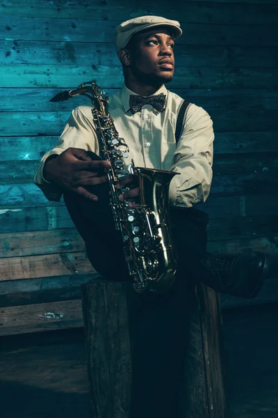 Músico de jazz afroamericano con saxofón frente al viejo wo — Foto de Stock