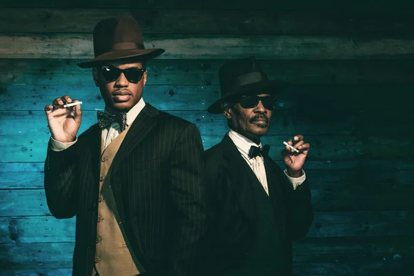 Två vintage afrikanska amerikanska gangsters röka cigarett i fron — Stockfoto