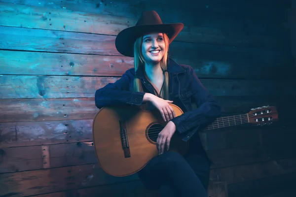 Cowgirl country zpěvačka s akustickou kytarou. Na sobě modré džíny — Stock fotografie