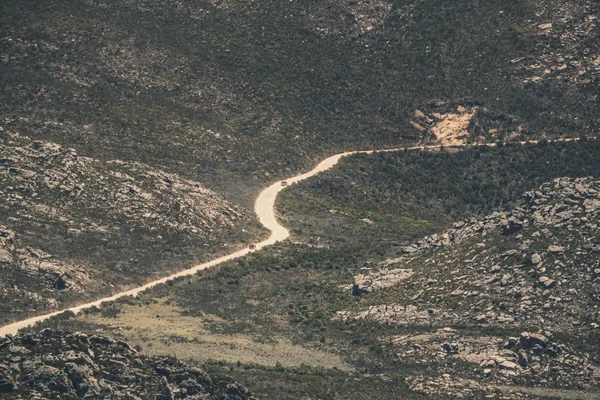 Deux voitures conduisent sur un chemin de terre dans le paysage montagneux du Swartberg. W — Photo