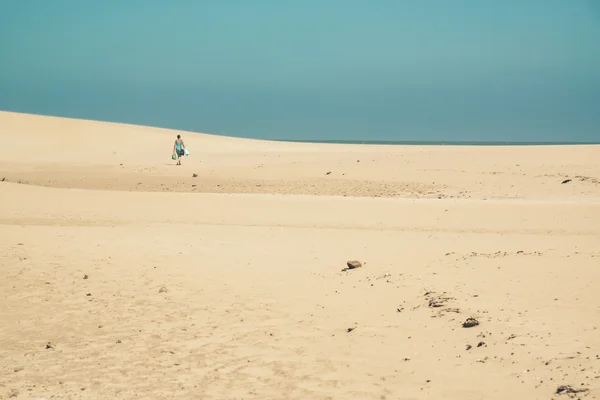 明亮的沙丘与向地平线走来的女游客。Cl — 图库照片