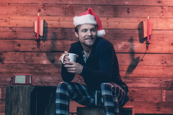 Man with blonde hair, beard and christmas hat wearing winter sle