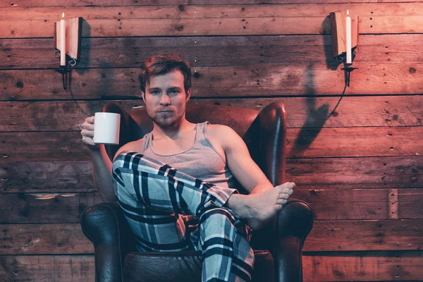 Homme aux cheveux blonds portant des vêtements de nuit d'hiver. Assis à Leathe — Photo