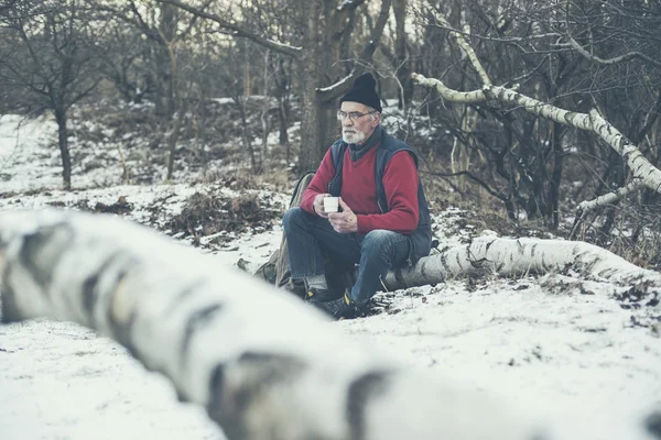 Älterer Mann im verschneiten Winterwald — Stockfoto