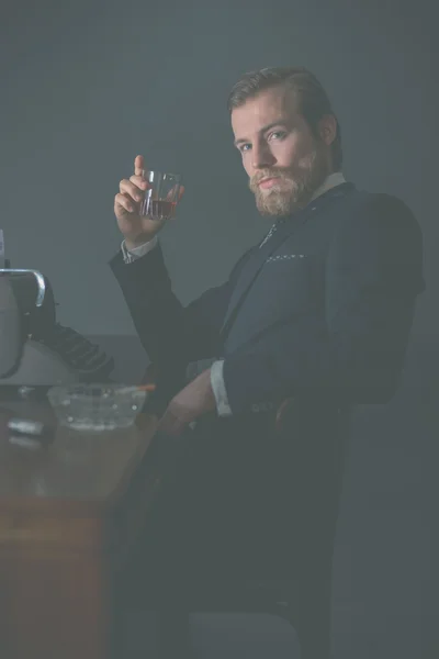 Retro businessman drinking in the office — Stock Photo, Image