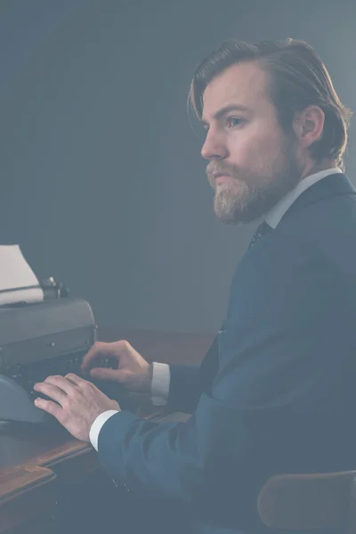 Biznesmen siedzi na maszynie do pisania — Zdjęcie stockowe